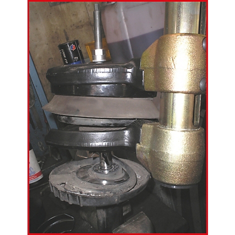 Nahaufnahme eines Stoßdämpfer-Druckwerkzeugs. Schwarze und silberne Elemente im Detail, verbunden mit goldenen Schrauben.